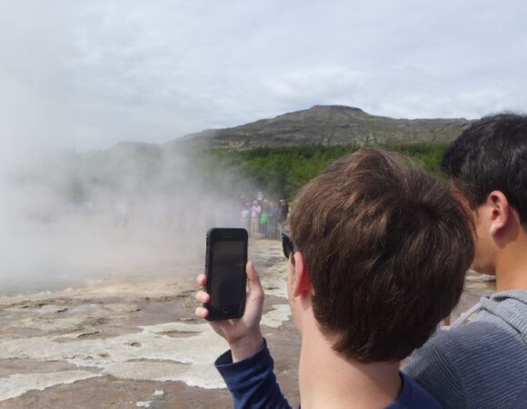 students taking photo of geyser using their phone