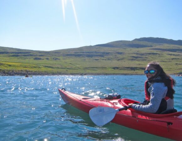 sunshine rays on person smiling in red kayak