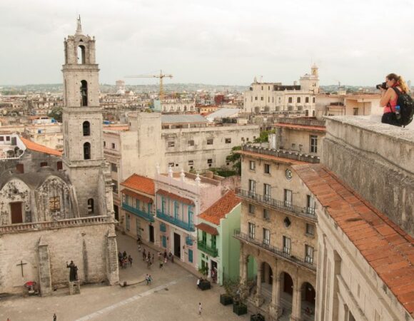 student taking photograph on cuban building rooftop